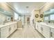 Spacious bathroom boasts dual sinks, large mirrors, a glass-enclosed shower, and wood floors at 4680 Peppertree St, Pahrump, NV 89061