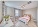 Cozy bedroom with a ceiling fan, window with floral curtains, and stylish decor on a white shelf at 4680 Peppertree St, Pahrump, NV 89061