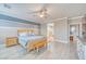 Bright main bedroom featuring wood floors, king bed with blue accents, and ensuite bathroom access at 4680 Peppertree St, Pahrump, NV 89061