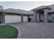 Attached two-car garage with brick driveway, stone facade accents, and well maintained artificial turf at 4739 Laurel Canyon St, Las Vegas, NV 89129