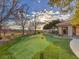 Backyard putting green with manicured landscaping and mature trees at 5 Mountain Cove Ct, Henderson, NV 89052