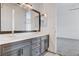 Elegant bathroom features double vanity with gray cabinets and access to bedroom; tile flooring at 5148 Villa Vecchio Ct, Las Vegas, NV 89141