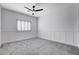 A cozy bedroom with modern wainscoting and plush gray carpeting, enhanced by a stylish ceiling fan at 5148 Villa Vecchio Ct, Las Vegas, NV 89141