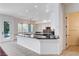 Open kitchen with white cabinetry, modern fixtures, and a granite countertop peninsula at 5148 Villa Vecchio Ct, Las Vegas, NV 89141