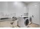 Bright laundry room with stainless steel utility sink and modern, front-loading washer and dryer at 5148 Villa Vecchio Ct, Las Vegas, NV 89141