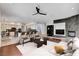 Open-concept living room with stone fireplace, ceiling fan, and kitchen with breakfast bar at 5148 Villa Vecchio Ct, Las Vegas, NV 89141
