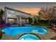 Backyard pool and hot tub with well-maintained lawn and colorful lounge chairs at 5148 Villa Vecchio Ct, Las Vegas, NV 89141