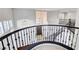 View of the curved staircase with wrought iron balusters and view of the front entry chandelier at 5148 Villa Vecchio Ct, Las Vegas, NV 89141