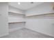 A spacious walk-in closet with ample shelving and wooden rods, perfect for organized storage and clothes at 5148 Villa Vecchio Ct, Las Vegas, NV 89141