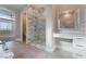 Modern bathroom with a marble shower, vanity area, and tile flooring; adjacent to another room at 5371 Brevin Ct, Las Vegas, NV 89131