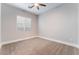 Cozy bedroom with carpeted floors, window, and ceiling fan at 5371 Brevin Ct, Las Vegas, NV 89131