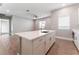 Kitchen island with white countertops, stainless steel sink, and wood-look flooring in an open layout at 5371 Brevin Ct, Las Vegas, NV 89131