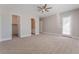 Spacious main bedroom with neutral tones, carpet flooring, ceiling fan, and adjoining bathroom with walk-in closet at 5371 Brevin Ct, Las Vegas, NV 89131