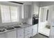 Bright kitchen featuring white cabinetry, stainless steel sink and faucet, and built-in appliances at 5580 E Carey Ave, Las Vegas, NV 89156