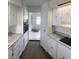 Long kitchen featuring light countertops, white cabinets, and wood-look floors at 5580 E Carey Ave, Las Vegas, NV 89156