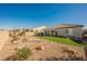 A well-maintained backyard featuring artificial turf, rock landscaping, potted plants, and a covered patio at 6225 Gambetta St, Las Vegas, NV 89115
