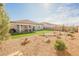 A serene backyard with artificial grass, covered patio, rock landscaping, and vibrant potted flowers at 6225 Gambetta St, Las Vegas, NV 89115
