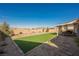 Fully landscaped backyard with artificial turf and desert landscaping that creates a serene outdoor space at 6225 Gambetta St, Las Vegas, NV 89115