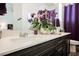 Bathroom with wood-look tile flooring, double sinks, and an elegant purple shower curtain at 6225 Gambetta St, Las Vegas, NV 89115