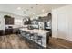 A gourmet kitchen features a large island, stainless appliances, pendant lighting, and dark wood cabinetry at 6225 Gambetta St, Las Vegas, NV 89115