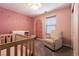 Bedroom featuring neutral walls, a white crib, and a comfortable rocking chair at 6308 Gulf Waters St, North Las Vegas, NV 89081