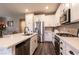 Modern kitchen with stainless steel appliances, white cabinets, and stone countertops at 6308 Gulf Waters St, North Las Vegas, NV 89081