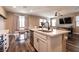 Bright kitchen features an island with white countertops, stainless steel appliances and a dining area at 6308 Gulf Waters St, North Las Vegas, NV 89081