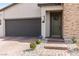 Close-up of front door with brick accents, a two-car garage, and drought-tolerant landscaping at 6726 N Palmer Estates St, North Las Vegas, NV 89086