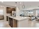 Open concept kitchen and living room with stainless steel appliances, large island, and pendant lighting at 6726 N Palmer Estates St, North Las Vegas, NV 89086