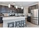Stylish kitchen featuring stainless steel appliances, spacious island with seating, and dark cabinets at 6726 N Palmer Estates St, North Las Vegas, NV 89086