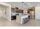 Modern kitchen features stainless steel appliances, dark wood cabinetry, quartz countertops, and a large center island with seating at 6726 N Palmer Estates St, North Las Vegas, NV 89086