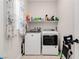 Functional laundry room with modern washer and dryer and overhead shelving at 6726 N Palmer Estates St, North Las Vegas, NV 89086