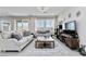 Comfortable living room with large windows, neutral furniture, and an area rug at 6726 N Palmer Estates St, North Las Vegas, NV 89086