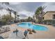 Inviting community pool with lounge chairs and tables, surrounded by palm trees at 6745 Caporetto Ln # 104, North Las Vegas, NV 89084