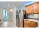 Modern kitchen with stainless steel refrigerator, wood cabinets, and views of the bedroom at 6745 Caporetto Ln # 104, North Las Vegas, NV 89084