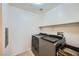 A functional laundry room with modern washer and dryer units and storage at 6745 Caporetto Ln # 104, North Las Vegas, NV 89084