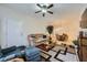 Inviting living room with large windows and access to dining area with a modern ceiling fan at 6745 Caporetto Ln # 104, North Las Vegas, NV 89084