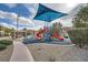 Community playground featuring a colorful play structure and shaded seating area at 6745 Caporetto Ln # 104, North Las Vegas, NV 89084