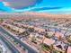 Expansive aerial view of a neighborhood showcasing homes with red terracotta roofs and solar panels at 7479 Lassen Peak Cir, Las Vegas, NV 89149