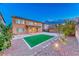 Two-story home with a grass backyard area with a brick paver patio at 7479 Lassen Peak Cir, Las Vegas, NV 89149