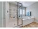Bright bathroom showcasing glass enclosed shower, tub, and a built-in shelving unit at 7479 Lassen Peak Cir, Las Vegas, NV 89149
