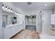 Bright bathroom featuring a double vanity, glass shower, and a walk-in closet for ample storage at 7479 Lassen Peak Cir, Las Vegas, NV 89149