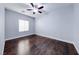 Cozy bedroom with hardwood floors, ceiling fan, and ample natural light from the window at 7479 Lassen Peak Cir, Las Vegas, NV 89149