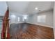 Spacious living room featuring hardwood floors, large windows, and a staircase with wood railing at 7479 Lassen Peak Cir, Las Vegas, NV 89149