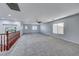 Carpeted loft featuring a railing that overlooks the staircase, with multiple windows providing natural light at 7479 Lassen Peak Cir, Las Vegas, NV 89149