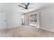 This bright bedroom has neutral carpet, a ceiling fan, and sliding glass doors to the outside at 849 Parkhurst St, Las Vegas, NV 89110