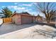 Wide driveway leading to an attached two-car garage with brick facade and a wooden fence creating private yard space at 849 Parkhurst St, Las Vegas, NV 89110