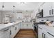 Sleek kitchen featuring white cabinetry, quartz countertops, stainless steel appliances, and wood-look flooring at 849 Parkhurst St, Las Vegas, NV 89110
