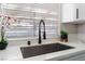 The kitchen sink has modern black fixtures, a large window, and bright countertops at 849 Parkhurst St, Las Vegas, NV 89110
