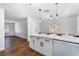 Modern kitchen with white cabinets, a quartz countertop island, and stainless steel appliances, open to living area at 849 Parkhurst St, Las Vegas, NV 89110